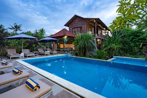 a villa with a swimming pool and a house at Dream Beach Inn in Nusa Lembongan