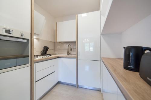 una pequeña cocina con armarios blancos y fregadero en Palma Luxury Apartment, en Ploče