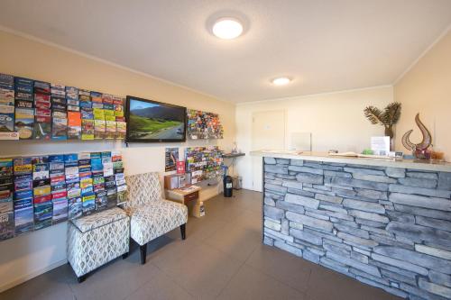 
a living room filled with furniture and a tv at Lomond Lodge Motel & Apartments in Queenstown
