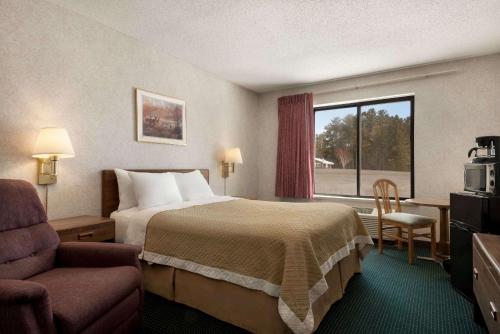 a hotel room with a bed and a window at Days Inn by Wyndham Eagle River in Eagle River