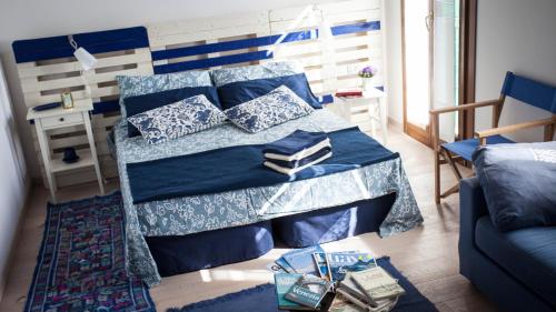 een slaapkamer met een bed met blauwe lakens en kussens bij B&b Hobo in Mira