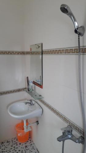 La salle de bains est pourvue d'un lavabo et d'une douche. dans l'établissement khach san thu thanh ly son, à Quảng Ngãi