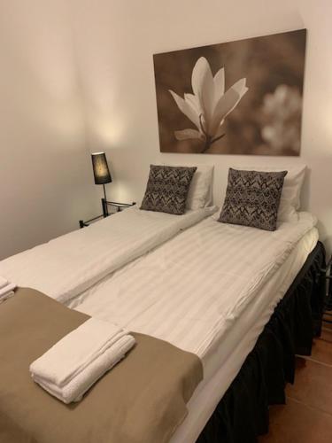 two beds with white sheets and pillows in a room at Mälarö Hotell in Ekerö