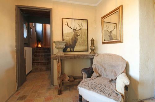 una habitación con una silla y una foto de un ciervo en LA GUINGUETTE DE BELLEME, en Bellême