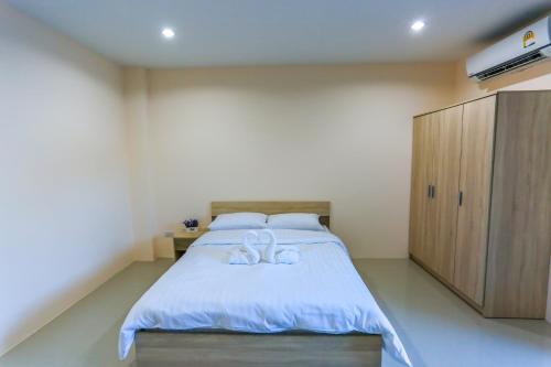 a bedroom with a bed with two white bows on it at Tempo Plus Apartment in Mae Sot