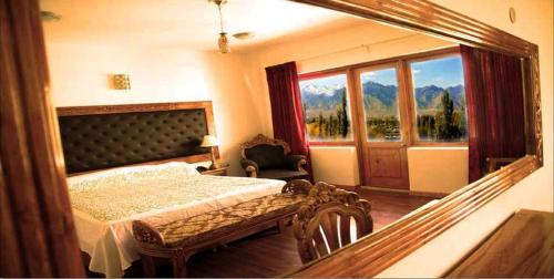 - une chambre avec un lit et un grand miroir dans l'établissement Hotel Grand Himalaya, à Leh