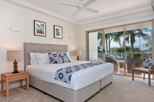 a bedroom with a large bed and a balcony at Offshore Noosa Resort in Noosaville