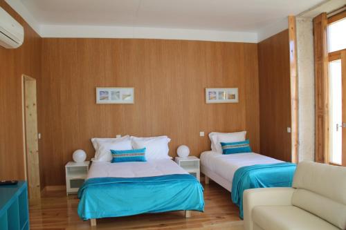 een slaapkamer met 2 bedden en een bank bij Loulé Estúdios in Porto