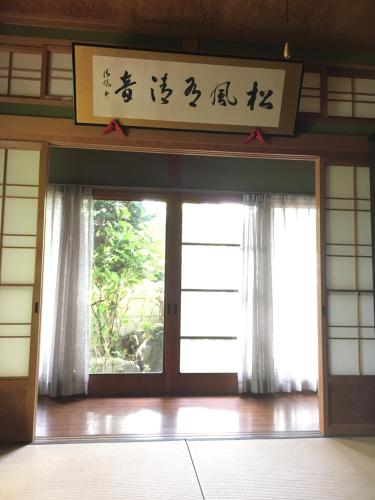 a door in a building with a sign above it at Guest House Ilonggo in Tsu