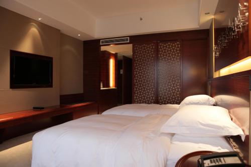 a bedroom with two beds and a flat screen tv at Huangyan Yaoda Hotel in Taizhou