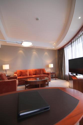 a living room with a couch and a tv at Huangyan Yaoda Hotel in Taizhou