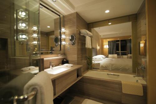 łazienka z umywalką i dużym lustrem w obiekcie Huangyan Yaoda Hotel w mieście Taizhou