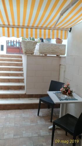 a room with stairs and a table and chairs at Villetta Carati in Torre dell'Orso