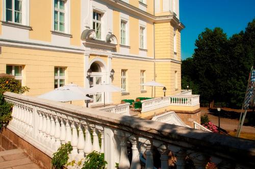 a balcony with umbrellas in front of a building at Hotel Schloss Schwarzenfeld in Schwarzenfeld