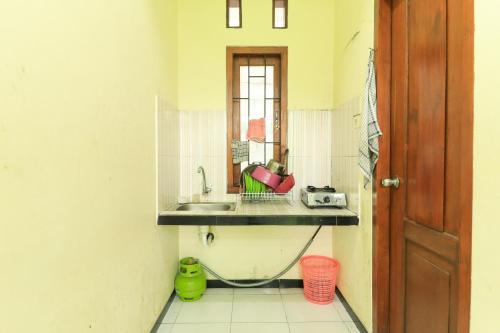 a small kitchen with a sink and a window at Villa Kangen Omah in Mojokerto