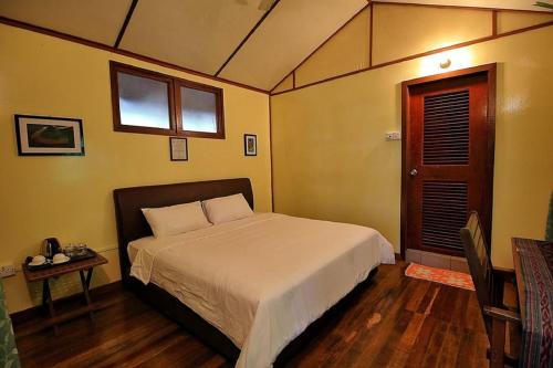 Un pat sau paturi într-o cameră la Nature Lodge Kinabatangan