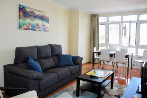 a living room with a couch and a table at Apartamento en centro de Fisterra in Fisterra