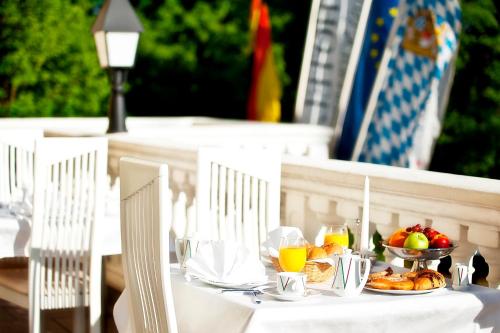a table with a plate of food and fruit on it at Hotel Schloss Schwarzenfeld in Schwarzenfeld