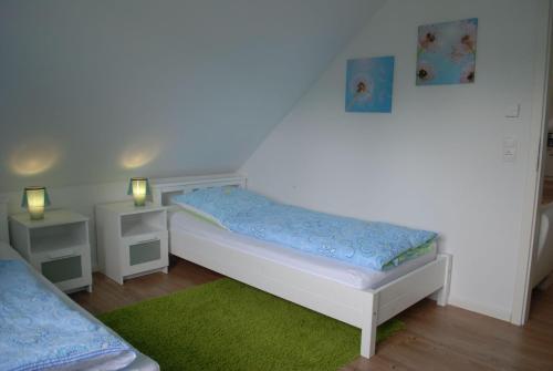 a small bedroom with a white bed and a green rug at Ferienwohnung-Luett-Gammelby in Gammelby