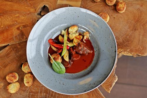 a bowl of food on a table with tomato sauce at Hotel Lajta Park in Mosonmagyaróvár