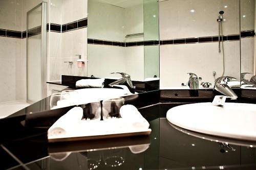 a bathroom with two sinks and a mirror at Hotel Schloss Schwarzenfeld in Schwarzenfeld