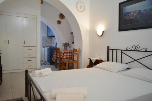 a bedroom with two beds and a dining room at Volta Stonehouse Apartments in Frátsia