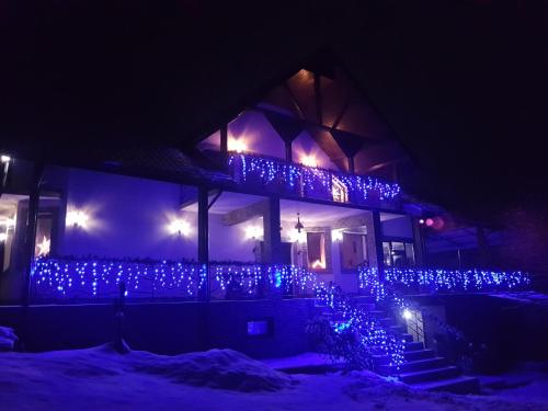 uma casa com luzes de Natal azuis à noite em Casa 4 Anotimpuri em Gura Bîscei