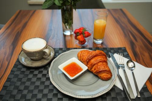 a table with a plate of croissants and a cup of orange juice at CHALET DILIJAN Hotel & Restauarant in Dilijan