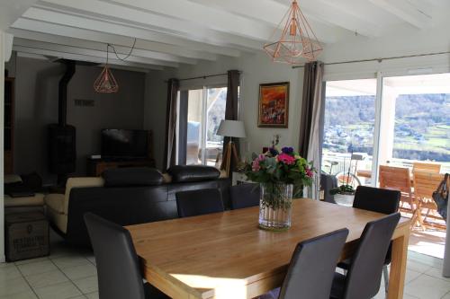 - un salon avec une table en bois et des fleurs dans l'établissement MAISON BELLEVUE 3 étoiles 4 à 10P, à Laruns