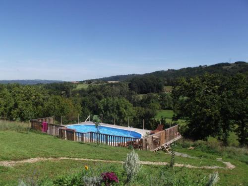 a large swimming pool in a field with trees at Aveyron West in Saint-Igest