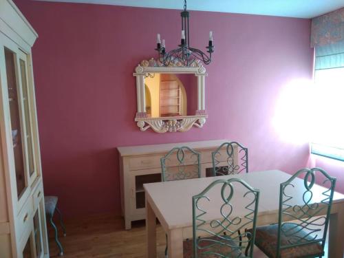 a dining room with a table and chairs and a mirror at Espacioso piso en el corazón de Oliva in Oliva