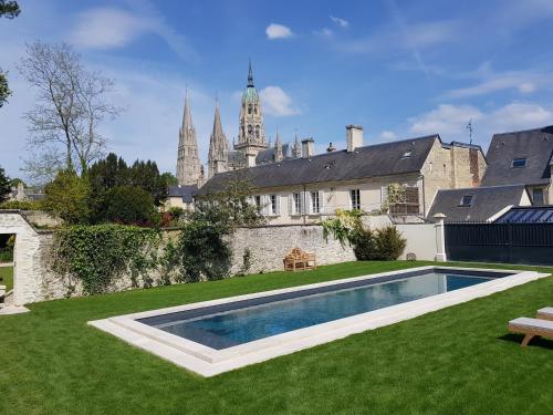 a house with a swimming pool in a yard at Le Tardif, Noble Guesthouse in Bayeux