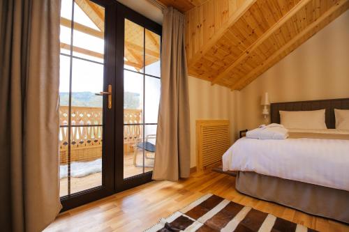 a bedroom with a bed and a balcony at CHALET DILIJAN Hotel & Restauarant in Dilijan