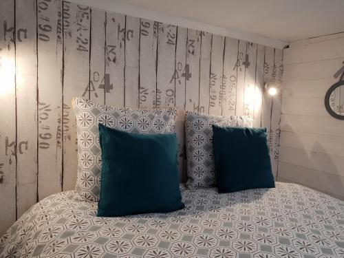 une chambre avec un lit avec deux oreillers bleus dans l'établissement Studio Du Marche, à Dinan