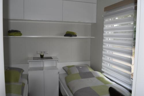a small bedroom with a bed and a window at Ferienapartment am See in Wettringen