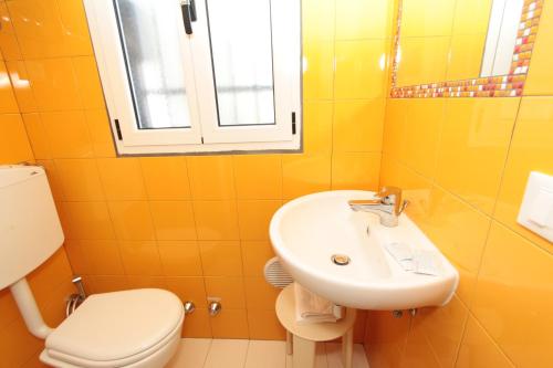 リド・ディリ・スカッキにあるHabitat 81の黄色のバスルーム(洗面台、トイレ付)