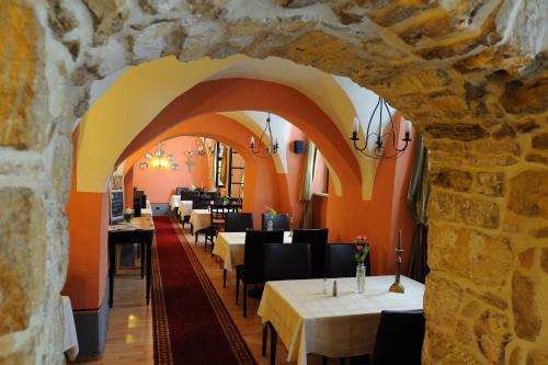 a dining room with tables and chairs and a stone wall at Braugasthaus in Naumburg