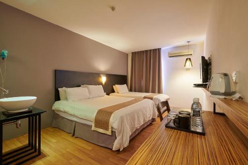 a hotel room with two beds and a sink at The Leverage Lite Hotel - Kuala Kedah in Alor Setar