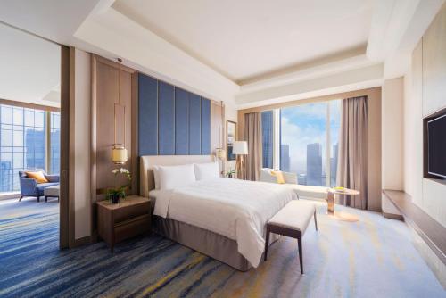 a hotel room with a bed and a large window at Shangri-La Yuanqu, Suzhou in Suzhou