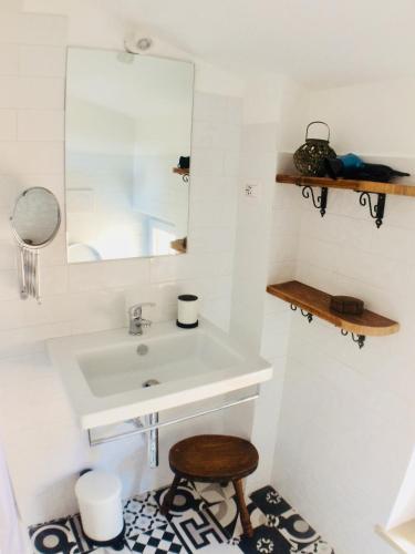 a bathroom with a sink and a mirror and a stool at ManillaHouse in Montepulciano