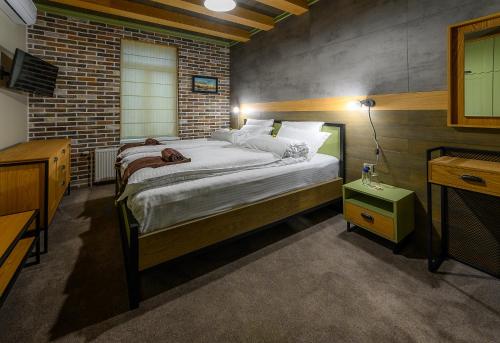 a bedroom with a bed and a brick wall at Vitality Guest House in Veliko Tŭrnovo