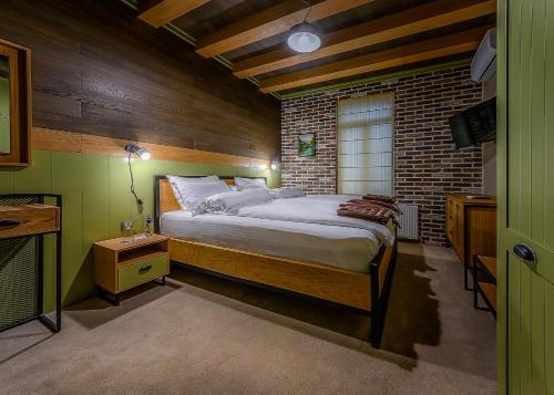 una camera da letto con un letto e un muro di mattoni di Vitality Guest House a Veliko Tŭrnovo