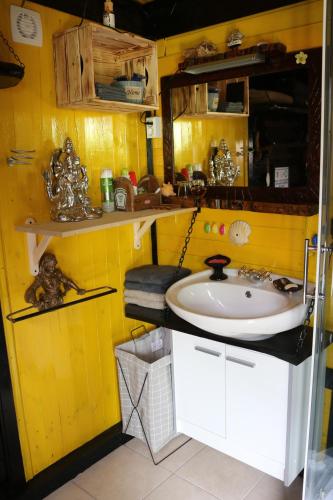 a bathroom with a sink and a yellow wall at Frenk cottage 5 KM FROM THE AIRPORT-free transportation in Šenčur