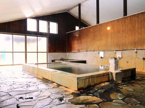 a large bath room with a large tub in a building at 布引観音温泉 in Ōhinata