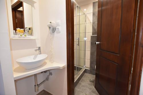 a bathroom with a sink and a shower at Rodakas Hotel in Akrotiri
