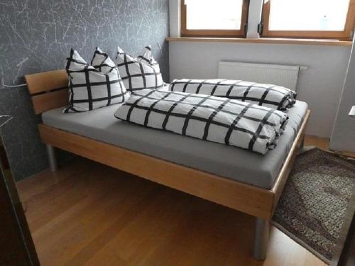 a bed with black and white pillows on it at Ferienwohnung Diepold in Wasserburg