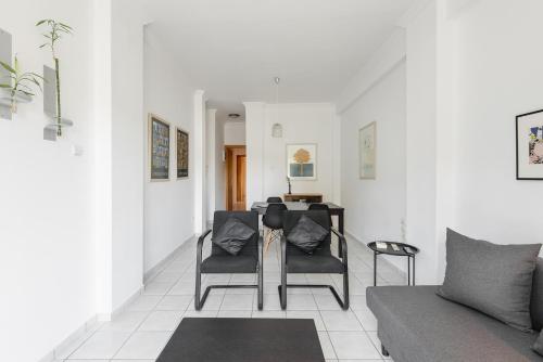 a living room with two chairs and a couch at Central Park View Apartment in Thessaloniki
