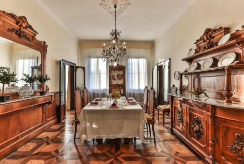 a dining room with a table and a chandelier at Ca Dei Greci Canal View in Venice