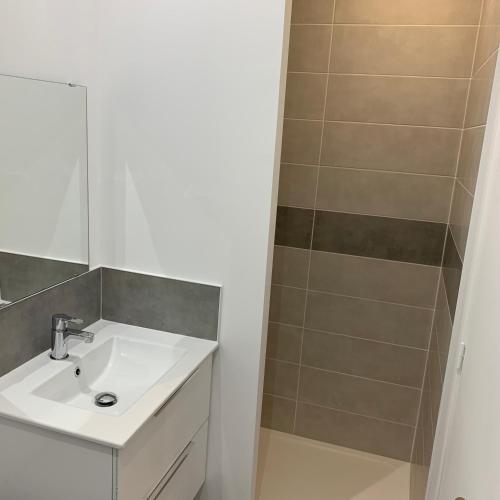 une salle de bain avec un lavabo et une douche dans l'établissement Musica, à Bray-Dunes