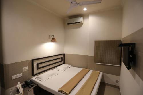 a small room with a bed and a fan at Smyle Inn - Best Value Hotel near New Delhi Station in New Delhi